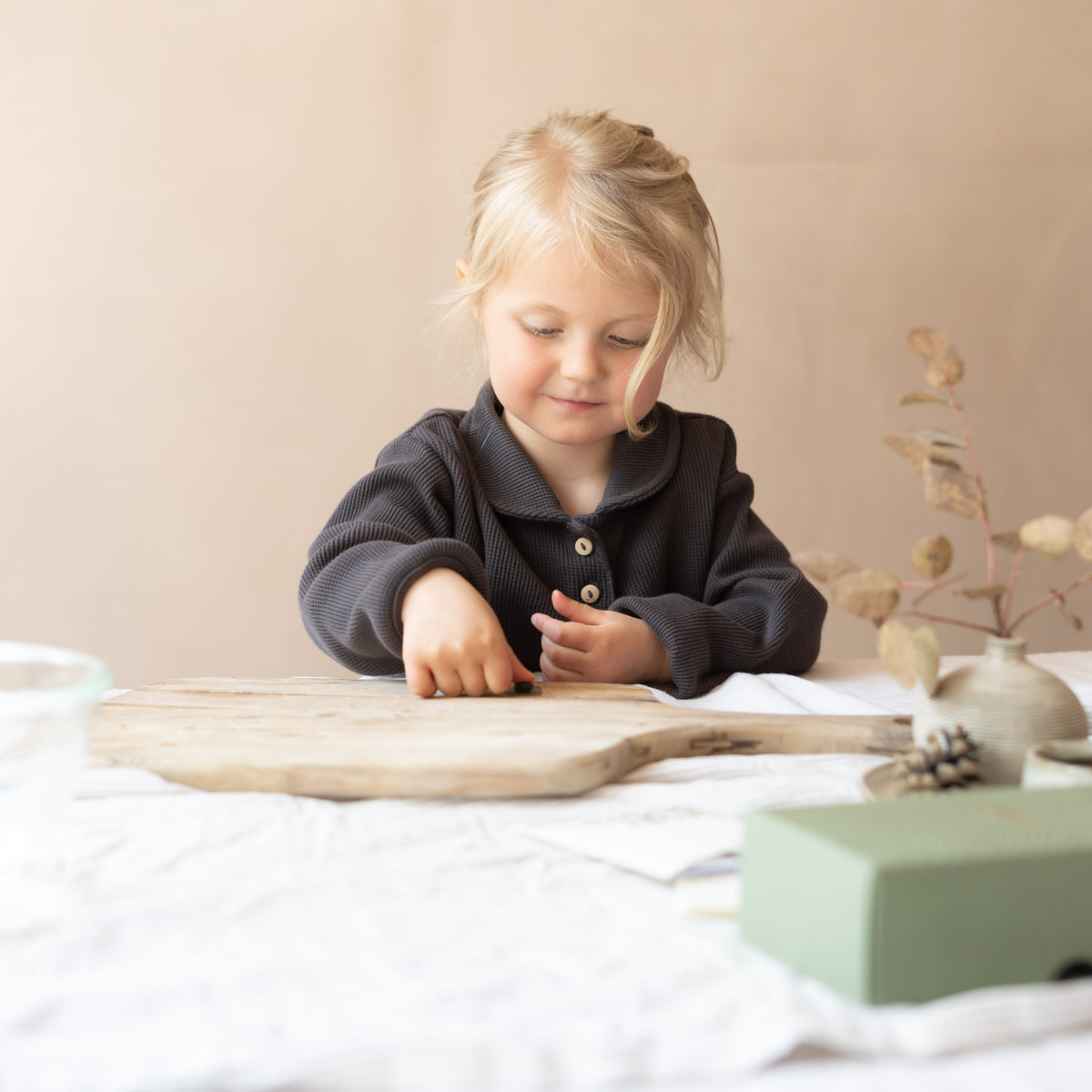 The impression: a child presses a hand into impression wax at a table